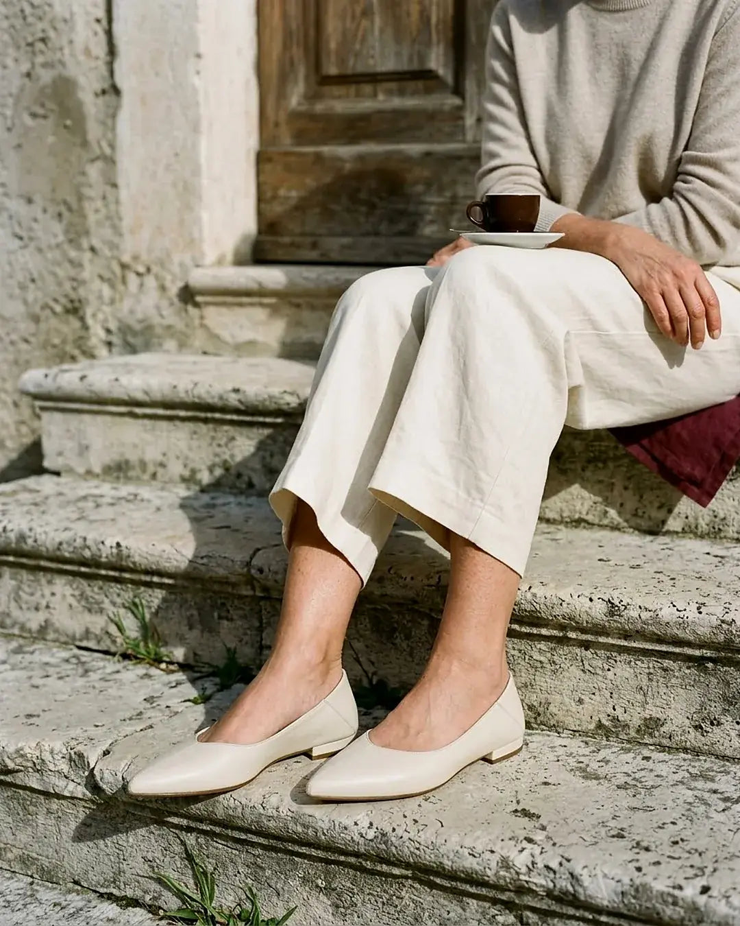 Ballerine a punta in pelle panna indossate su gradini di pietra – Vaccarelli