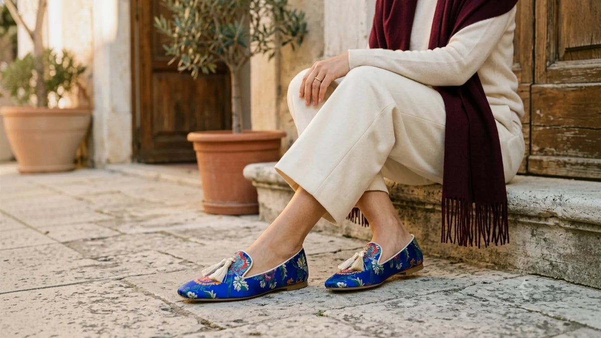 Donna seduta in un cortile di pietra con mocassini jacquard artigianali Vaccarelli